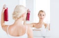 Woman with hairspray styling her hair at bathroom Royalty Free Stock Photo