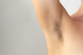 Woman hairy unshaved armpit holding arm aside on the white background with copy space