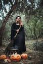 Woman in halloween witch costume in forest