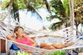 Woman in the hammock under the palms on the tropical beach