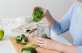 Woman hand adding pea to measuring cup