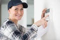 woman hand adjusting wall mounted thermostat temperature Royalty Free Stock Photo