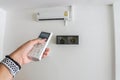 Woman hand with air conditioner remote control panel for temperature setting Royalty Free Stock Photo