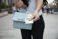 woman hand bag and money in street.