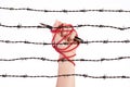 Woman hand with black pen tied with red rope and rusty sharp bare wire, depicting the idea of freedom of the press or expression.