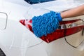 Woman hand with blue microfiber fabric washing taillight modern car or cleaning automobile. Royalty Free Stock Photo