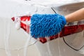 Woman hand with blue microfiber fabric washing taillight modern car or cleaning automobile. Royalty Free Stock Photo