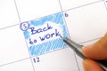 Woman hand with blue pen writing reminder Back to Work in calendar Royalty Free Stock Photo