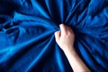 Woman hand on blue silk bedding, sex and orgasm concept Royalty Free Stock Photo