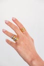 Woman hand with Bold Adjustable Golden and Silver Rings set against a white background