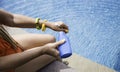 woman hand with  the bottle of sunblock outside in swim pool - summer healthy day concept Royalty Free Stock Photo