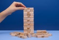 Woman hand build Jenga tower constructed