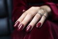 Woman hand with burgundy color nail polish on her fingernails. Burgundy nail manicure with gel polish at luxury beauty salon. Nail
