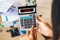 Woman hand calculating her expenses with unpaid financial bills ,credit cards on desk with word debt on calculator Royalty Free Stock Photo