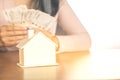 Woman hand calculating money with house model on wooden table planing to buy or rent home Royalty Free Stock Photo