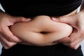 Woman hand catching fat body belly paunch , diabetic risk factor Royalty Free Stock Photo