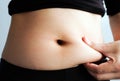 Woman hand catching fat body belly paunch , diabetic risk factor Royalty Free Stock Photo