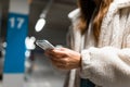 Woman hand with cell phone in hand in underground car parking. Royalty Free Stock Photo