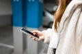 Woman hand with cell phone in hand in underground car parking. Royalty Free Stock Photo