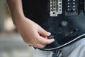 Woman hand changing electric guitar settings. Tuning a timbre regulator