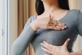 Woman hand checking lumps on her breast for signs of breast cancer. Women healthcare concept