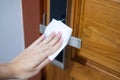 Woman hand cleaning digital door handle by wet wipe tissue, protection coronavirus or Corona Virus Disease Covid-19 at home. Royalty Free Stock Photo