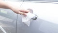 Woman hand cleaning removing germs with antibacterial wet wipes on car door handle for corona virus COVID-19 Royalty Free Stock Photo