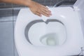 Woman hand cleaning toilet bowl by wet wipes before using in public restroom. Cleaning, Lifestyle, new normal and personal hygiene Royalty Free Stock Photo