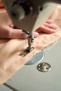 Woman hand close up sews tulle on electric sewing machine. Filling the thread into the sewing needle, adjusting the