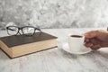 Woman hand coffee with glasses on book Royalty Free Stock Photo