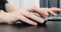 Woman hand with computer mouse, extra close up. Female fingers typing typing on laptop keyboard and mouse at office. Business con