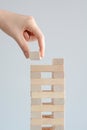 Woman hand constructing a tower of wooden blocks on a white background Royalty Free Stock Photo