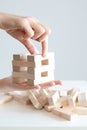 Woman hand constructing a tower of wooden blocks on a white background Royalty Free Stock Photo