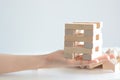 Woman hand constructing a tower of wooden blocks on a white background Royalty Free Stock Photo