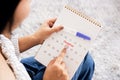 Woman hand counting the date on calendar checking her menstrual cycle planning for ovulation day another hand holding pregnancy