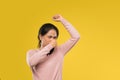 woman with hand covering nose while lifting armpit with smelly expression Royalty Free Stock Photo