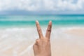Woman hand do peace out with blue sky beach Royalty Free Stock Photo