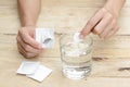 Woman hand dropping effervescent tablet in a glass of water Royalty Free Stock Photo