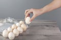 Woman hand eggs on box on table