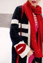 Woman hand in fake fur jacket with lips, stylish female sleeve detail in red scarf, fashionable coat