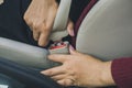 Woman hand fastening a seat belt before driving
