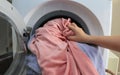 Woman hand filling laundry in the washing machine, housewife and hygienic,woman taking color clothes from washing machine. A drum