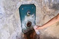 Woman hand fills a plastic bottle of water from a fountain in the wall. Thirsty and water crisis concept