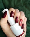 Woman hand finger black and red flower manicure gel nail polish swatch design white bottle beauty fashion photo