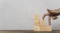 Woman hand finger walk on stacked wooden block like stairs, rises on the steps. Business development Royalty Free Stock Photo