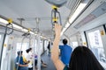 Woman hand firm grip safety handrail in elevated monorail train. Mass transit system in modern city. Inside of electric train.