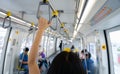 Woman hand firm grip safety handrail in elevated monorail train. Mass transit system in modern city. Inside of electric train.