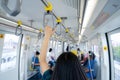 Woman hand firm grip safety handrail in elevated monorail train. Mass transit system in modern city. Inside of electric train.