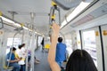 Woman hand firm grip safety handrail in elevated monorail train. Mass transit system in modern city. Inside of electric train.