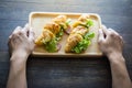 Woman hand freshly baked croissants with green vegetable on wood plate Royalty Free Stock Photo